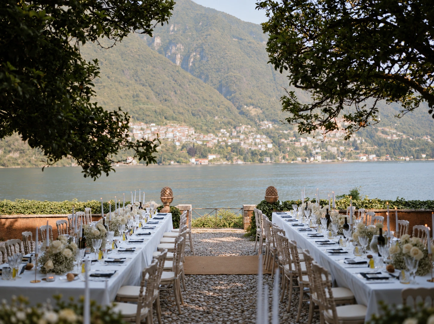 A long wedding dinner beside the lake framed by trees and mountains